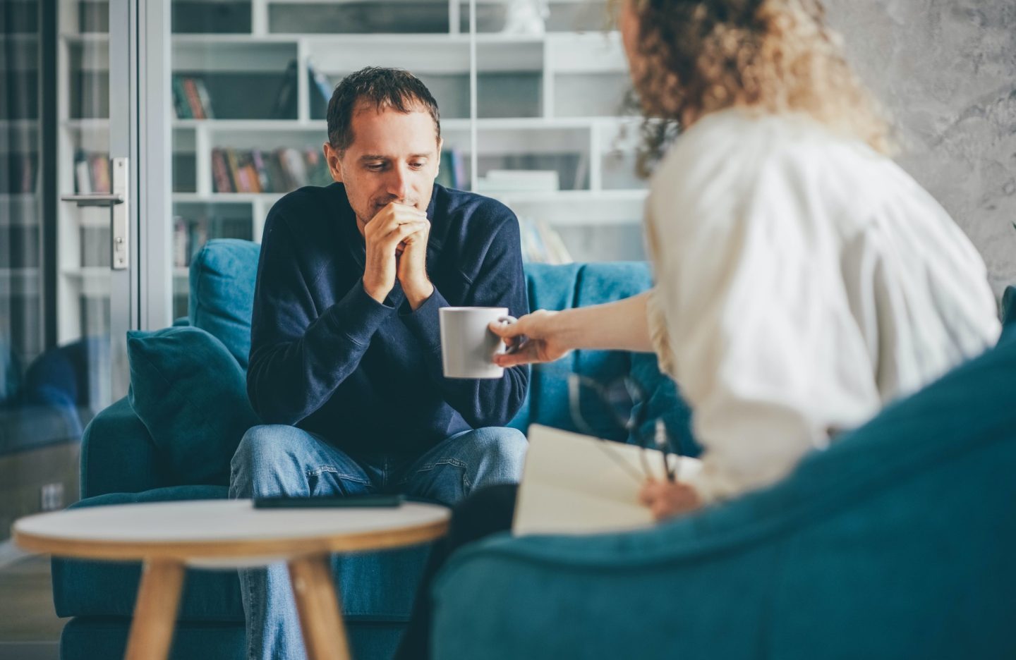 curly-haired-woman-consultant-offers-cup-of-coffee-to-stressed-man-client.jpg curly-haired-woman-consultant-offers-cup-of-coffee-to-stressed-man-client.jpg